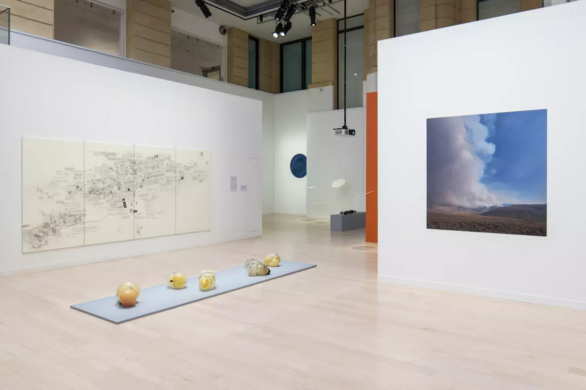Weiße Mila-wall Wände mit Zeichnung und Fotografie im Canadian Cultural Centre in Paris, davor Objekte auf einem flachen Podest